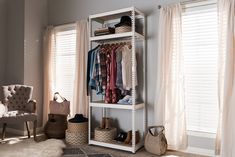 a white shelving unit with clothes and shoes