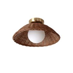 a light that is on top of a wicker ceiling fixture with a white wall in the background