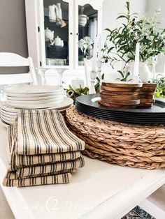 plates and napkins are stacked on top of each other in front of a basket