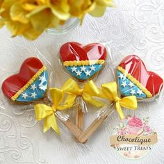 three heart shaped lollipops with bows on them sitting next to each other