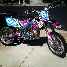 a pink dirt bike parked on the sidewalk