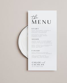 a white plate with a menu on it next to a black and white dinner card