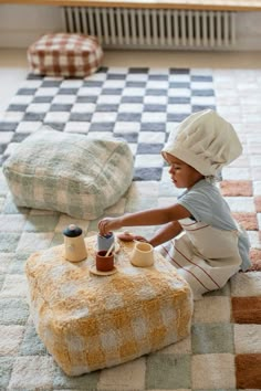 a little boy sitting on the floor playing with his toys