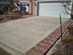 a driveway in front of a house with a white garage door