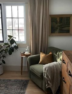 a living room filled with furniture and a large window covered in curtained drapes