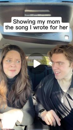 a man and woman sitting in the back seat of a car talking to each other