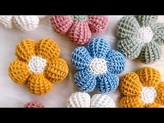 crocheted flowers are arranged on a white surface