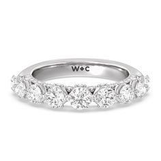 a white gold ring with five diamonds on the side and an inscription that reads wwc