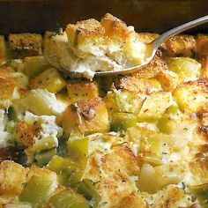 a casserole dish with bread and vegetables in it is being spooned into the casserole