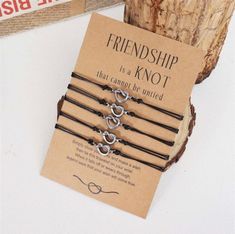 four bracelets with hearts on them are sitting next to a card that says, friendship is a knot that cannot be united