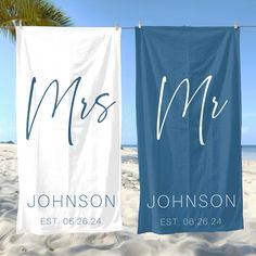 two personalized beach towels hanging on a clothes line at the beach with palm trees in the background