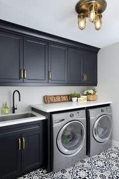 a washer and dryer in a room with black cabinets