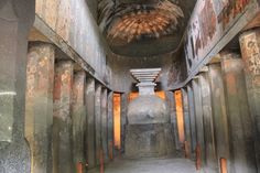 the inside of an old building with lots of cement pillars and rusted metal pipes