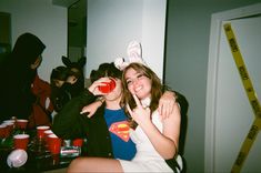 two girls dressed up as superman and bunny ears, posing for the camera with their arms around each other