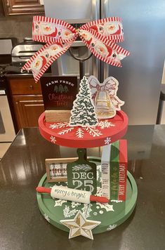 a christmas tree made out of books on top of a tray with ribbon and decorations