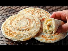 a person is holding a pita sandwich in their hand while they are on a cooling rack