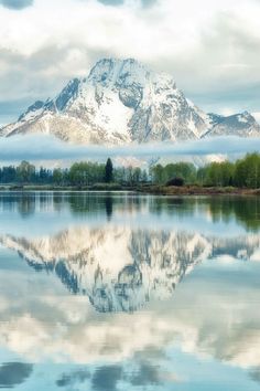 the mountains are reflected in the still water