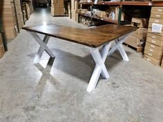 a wooden table sitting in a warehouse next to boxes