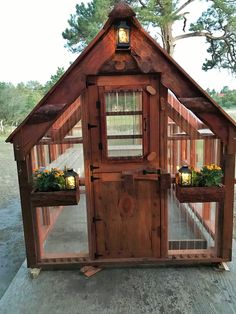 a small wooden building with plants growing inside