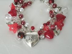 "Red Heart Charm Bracelet This beautiful bracelet has glass pearl beads, red glass beads, silver plated bead caps, lucite flower beads, sterling silver plated chain and pewter silver charms. 7\" long can be adjusted to 9\". Silver plated lobster clasp." Cheap Vintage Jewelry For Valentine's Day, Elegant Beaded Bracelets With Charms For Valentine's Day, Heart-shaped Beaded Bracelets For Valentine's Wedding, Heart-shaped Beaded Bracelets For Wedding On Valentine's Day, Vintage Beaded Jewelry For Valentine's Day, Valentine's Day Beaded Charm Bracelet, Red Metal Heart Bracelet As Gift, Red Metal Heart Bracelet Gift, Vintage Bracelet Jewelry For Valentine's Day