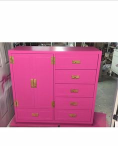 a pink dresser with gold handles and drawers