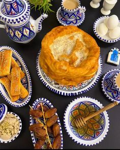 a table topped with plates and bowls filled with different types of food next to each other