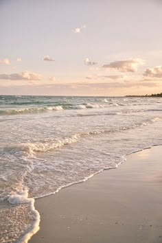 two people walking on the beach with surfboards