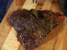 a piece of steak sitting on top of a wooden cutting board