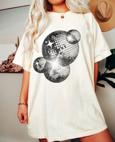 Comfort Colors Retro Disco Ball Oversized Tee Perfect for a Brides Last Disco Themed Bachelorette Party Or Any Fun Club Tee Machine wash inside out with like colors. Tumble dry on low to medium heat. Do not iron directly on image. Please refer to size chart for reference before purchasing. If you want an oversized fit, go up 1-2 sizes. Please feel free to message with any questions. Please note, since items are made to order, we do not accept cancellations, returns or exchanges. Please make sure all sizing and shipping information is correct before placing an order! Mockups are used for demonstration purposes only, and the final product may vary slightlty in color and placement due to printing and computer monitors. Disco Bachelorette Party T-shirts & Tank Tops, Chromatica Ball T Shirt, Relaxed Fit Cotton Party Tops, Summer Disco Tops With Crew Neck, Summer Disco Top With Crew Neck, Relaxed Fit Cotton Tops For Party, Disco Style Cotton Short Sleeve Tops, Disco Style Cotton Top With Short Sleeves, Disco Style Crew Neck Tops With Letter Print