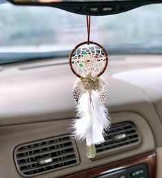 a car dashboard with a dream catcher hanging from the dash board