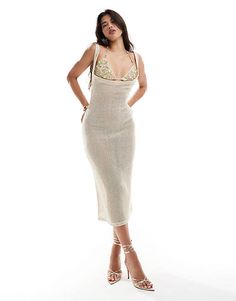 a woman in a white dress posing for the camera with her hands on her hips