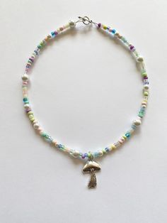 "️🍄 𝓰𝓾𝓶𝓭𝓻𝓸𝓹 𝓰𝓪𝓻𝓭𝓮𝓷 𝓷𝓮𝓬𝓴𝓵𝓪𝓬𝓮 ️🍄 FREE SHIPPING You will receive one necklace as seen in photos. Has a pastel rainbow and white color scheme. Made to order and beaded by me with luvvv <3 Strung on strong cord with a mixture of glass beads!! 🌹 Silver toggle clasp closure. Each necklace is unique with a different bead pattern but will look similar to photos. Looks great alone or layered with our mushroom garden necklace. Necklace variations - please choose when purchasing ( Cute Pastel Beaded Jewelry, Handmade Pastel Whimsical Jewelry, Whimsical Pastel Handmade Jewelry, Pastel Whimsical Handmade Jewelry, Handmade Multicolor Fairycore Jewelry, Whimsical White Beaded Necklaces, Trendy Beaded Necklace, 90s Indie, Pastel Necklace