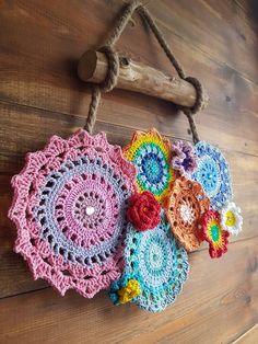 three crocheted doily hanging on a wooden wall with rope and wood hook