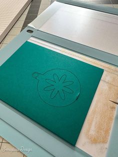 the cutting board is being used to cut out designs on paper and glues together