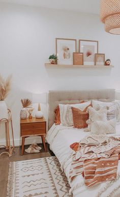 a bed room with a neatly made bed and some pictures on the wall above it