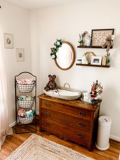 a wooden dresser sitting next to a mirror in a room on top of a hard wood floor