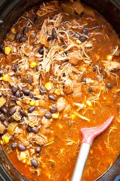 a crock pot filled with chicken, beans and corn