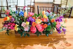 an arrangement of colorful flowers on a wooden table