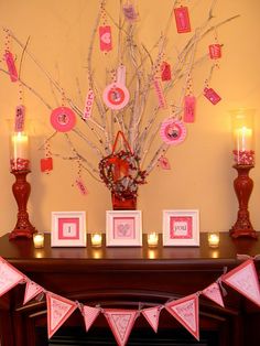 a decorated mantle with candles and pictures on the mantel for valentine's day