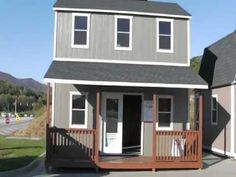 a small gray house with two windows and a porch