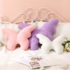 two stuffed animals are laying on a bed with flowers and a magazine next to it