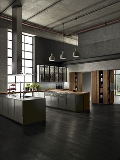 an industrial style kitchen with black cabinets and wood flooring is featured in this image