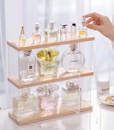 three tiered display case with perfume bottles on it