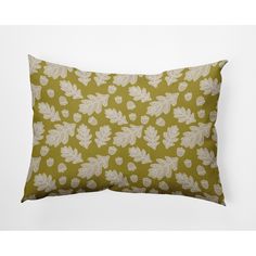 a green pillow with white leaves on it