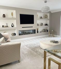 a living room filled with furniture and a flat screen tv mounted on the wall above a fireplace