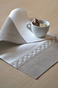 a white bowl filled with food sitting on top of a table next to a napkin