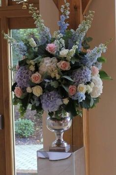 a vase filled with lots of flowers on top of a white countertop next to a door