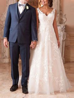 a bride and groom holding hands in front of a fireplace