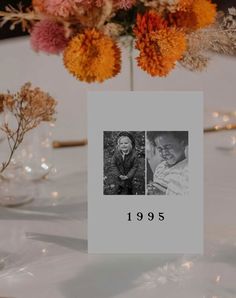 a table topped with vases filled with flowers and pictures on top of each other