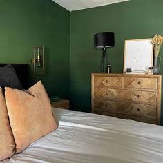 a bedroom with green walls and white bedding